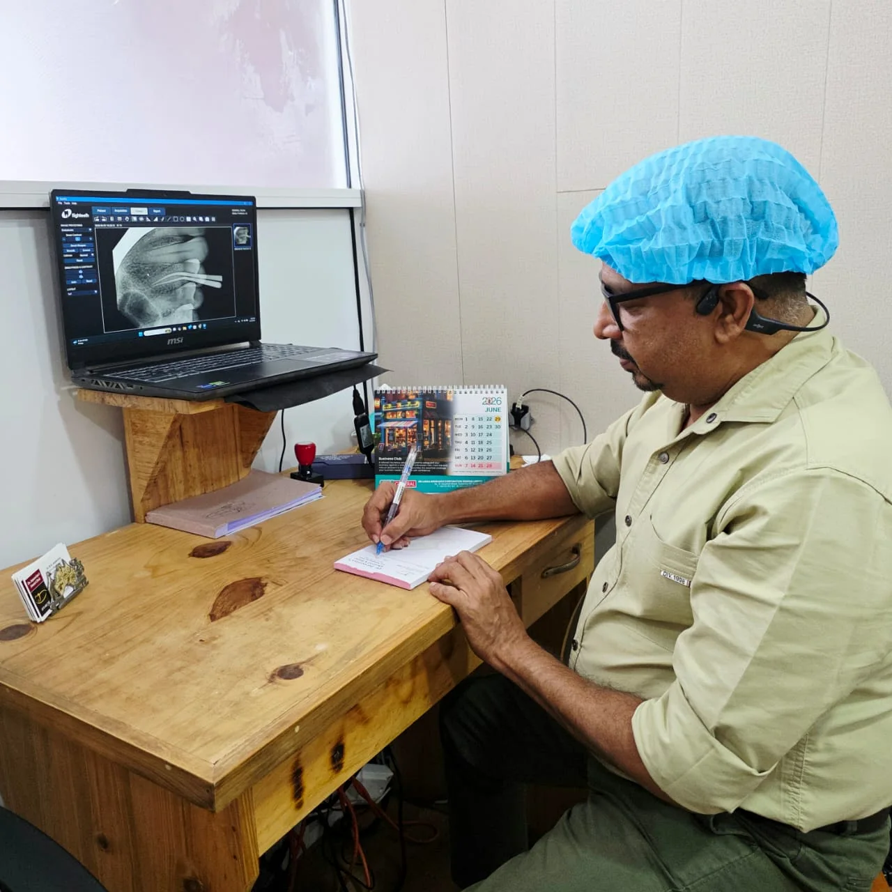 Dr. Jayasooriya reviewing a dental X-ray and preparing notes